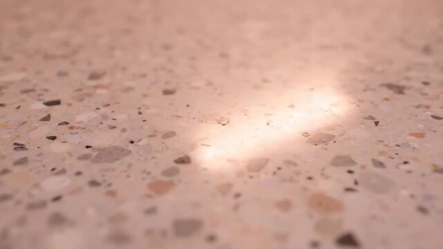 Polished Terrazzo Surface Texture Background with Soft Sunlight Reflection. Abstract Close-Up of Modern Architectural Stone Flooring or Countertop Detail.