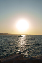Obraz premium Beautiful golden sunset over a calm lake with a boat on the water, creating a peaceful natural landscape in Croatia.