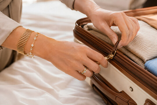 Woman packing clothes into a suitcase before a trip, representing travel preparation, vacation planning and organized packing