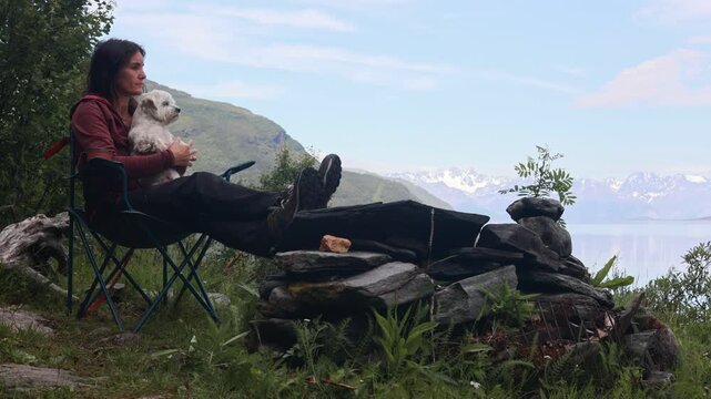 Woman, drinking coffee in the morning in front of a tent, wild camping in nature, Norway, morning, sunny morning