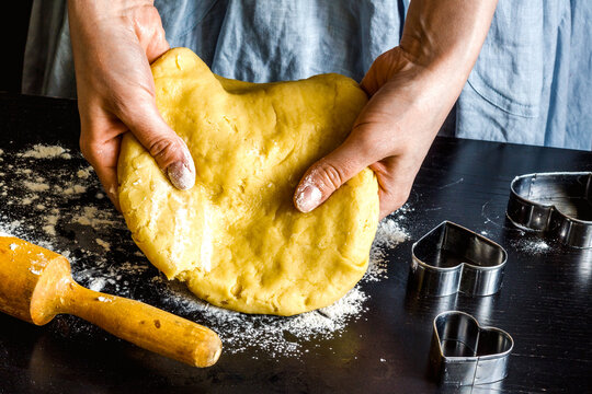 cooking homemade cookies with hands on dark background