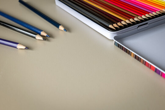 Colored Pencils Beside an Open Metal Tin with Copy Space