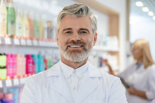 Two pharmacists in lab coats working in a pharmacy