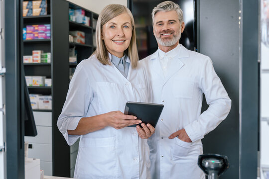 Man and woman in lab coats working together in the pharmacy