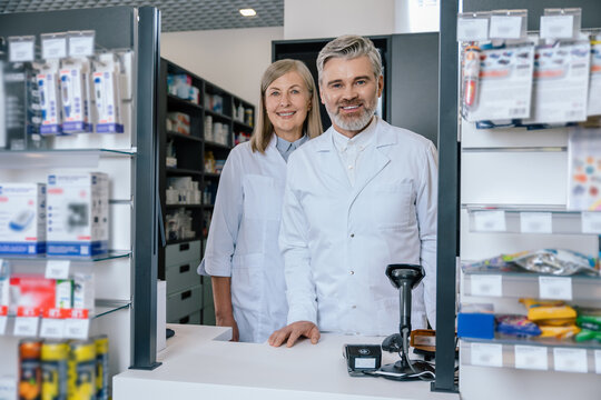 Man and woman in lab coats working together in the pharmacy