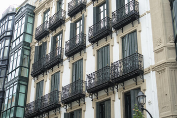 Glazed bay windows and iron balconies on historic town houses © Ekaterina