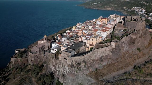 Panoramic aerial view of the Castelsardo, a medieval town in northern Sardinia (Sassari province) on the Gulf of Asinara. It features cascading, colorful houses and a historic fortress.