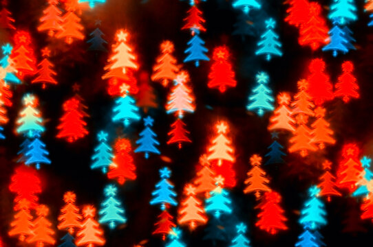 Christmas lights background with defocused festive multicolor bokeh lights, blue and red colors, abstract festive background with glowing color lights in form of the Christmas tree