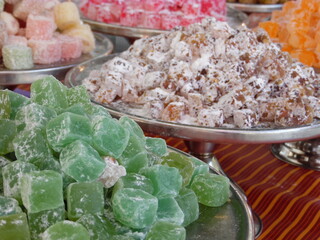 Fototapeta premium Vibrant green and golden turkish delight sweets displayed on silver platters