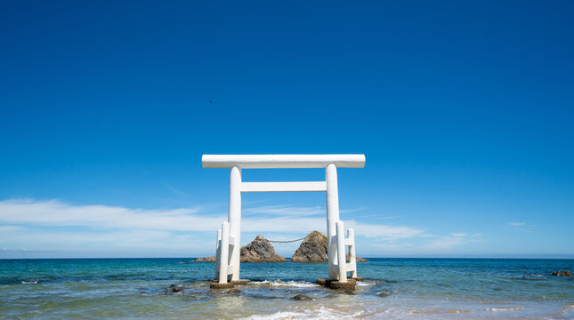 Meoto Iwa, white torii gate standing in the sea with sacred rocks in Itoshima, Fukuoka, Japan