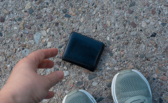 The lost wallet on the street, forgotten black leather object