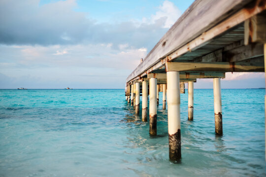 Wooden pier extending over turquoise ocean water
