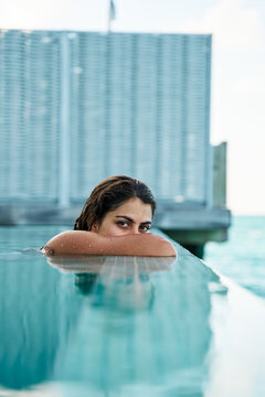 White Woman relaxing by the edge of a swimming pool
