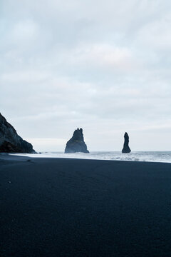 Black sand beach with ocean rock formations