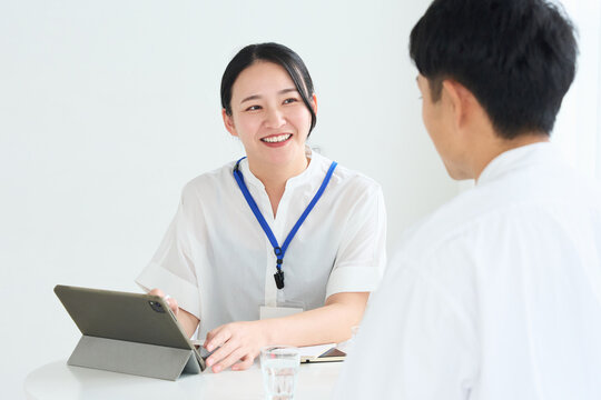Japanese Female Staff Explaining to Man at Reception Desk