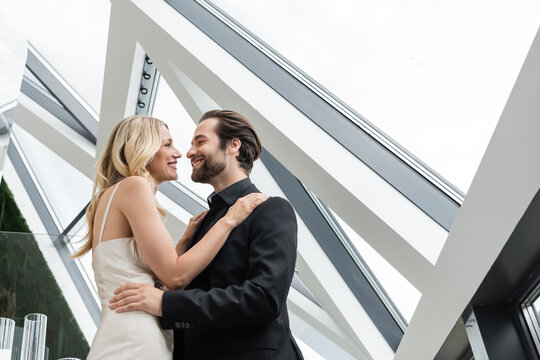 A joyful couple embraces as they celebrate their engagement on a stunning rooftop