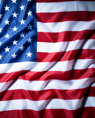 Fototapeta premium Close up of a draped American flag with stars and stripes, strong fabric folds and dramatic light creating a classic patriotic background.