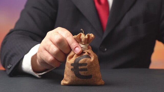 The businessmen offers grants or loans in the form of a euro money bag. Lend money. Mortgage, loan approval. Salary benefits. Attracting investments. Payment for services and work.