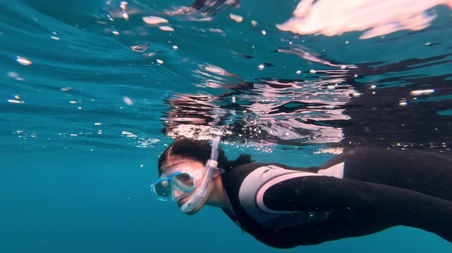 An underwater swimmer swimming on the surface of the blue sea in Sogod Bay, Padre Burgos, Philippines