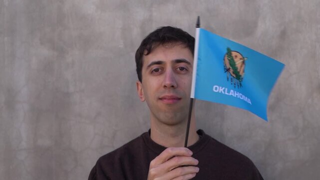 Person waving the state flag of Oklahoma in slow motion. Close up.