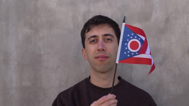 Male adult waving Ohio state flag. Slow motion.