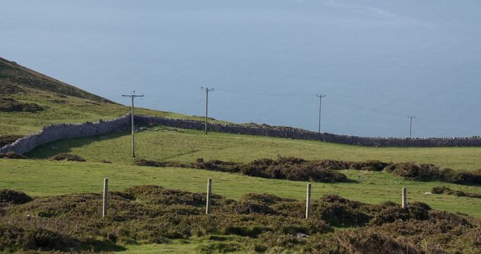 Wide shot looking down on to power Pylons, poles, telegraph poles at Great Orme head, summit.