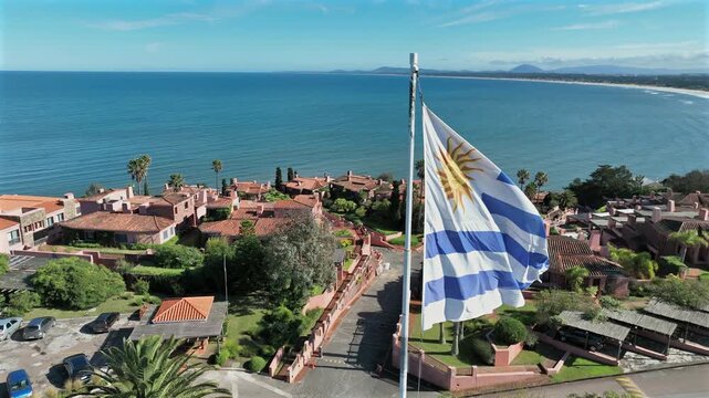 Uruguay flag reveal over Punta Ballena revealing Portezuelo Bay and the coastal neighborhood shoreline