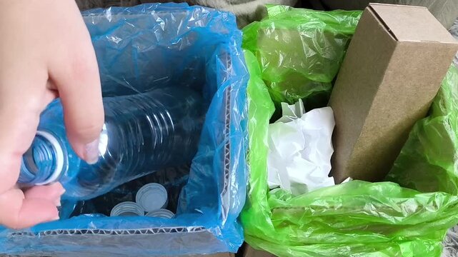 Woman sorting household waste into recycling bins, throwing away plastic bottles, plastic cups, cardboard and paper for recycling.