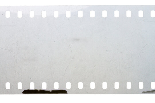 Dusty and grungy 35mm film texture or surface. Perforated scratched camera film isolated on white background.