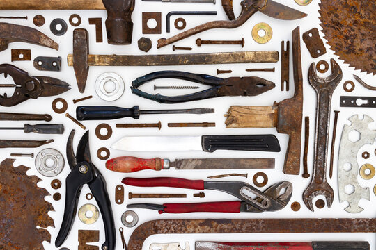 Flat lay of old hand tools on white background. Large collection of various rusty tools and bits arranged on white.