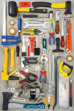 Flat lay of old and new hand tools on concrete background. Large collection of various tools and bits arranged on concrete.