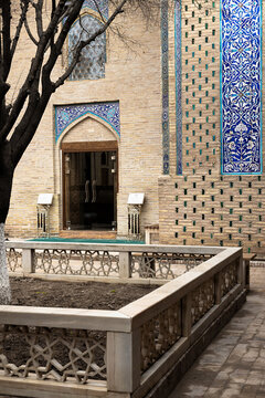 Pahlavan Mahmud Mausoleum courtyard entrance with blue tilework and geometric balustrade in Khiva Uzbekistan. Historic Islamic architecture ideal for travel publications and cultural heritage content.