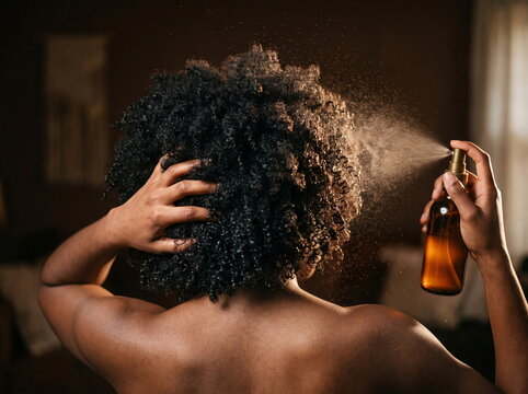 Woman Applying Hydrating Hair Mist and Styling Curly Hair Care Routine