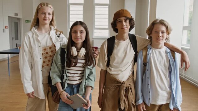 Portrait of teenagers standing in school corridor, smiling at camera during slow zoom in. Footage is perfect for high school enrollment campaigns and educational marketing promotions