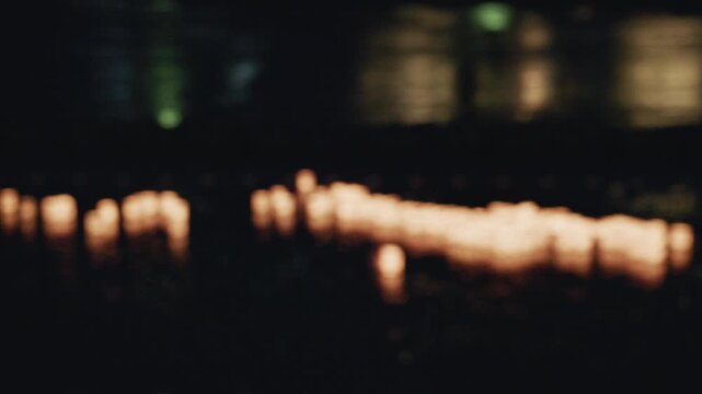 Blurred Light Passes Foreground of Floating Lanterns on River at Night