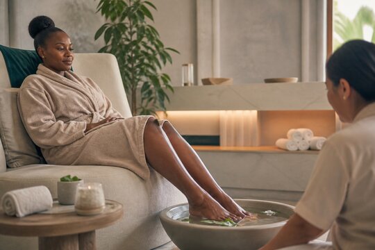 Woman relaxing with feet in soak bowl at luxury spa