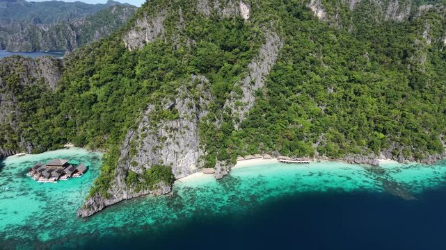 Aerial Drone View of Tropical Island Coastline with Turquoise Lagoon and Bungalows in Coron Philippines