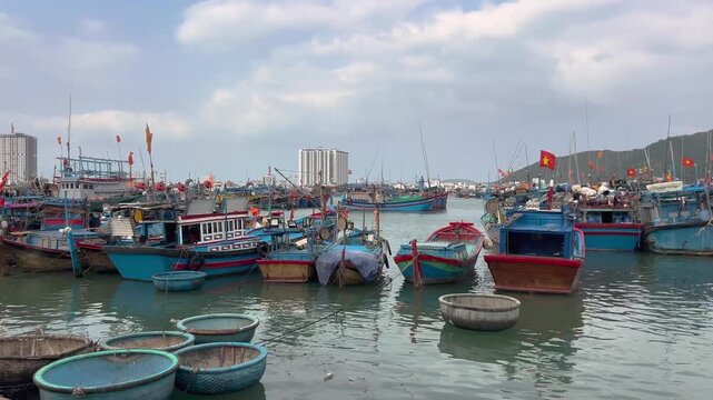 Panning shot of traditional wooden fishing boats and coracle boats at harbor in Nha Trang Vietnam