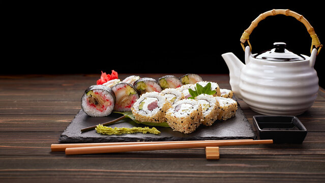 Assorted sushi rolls with teapot set