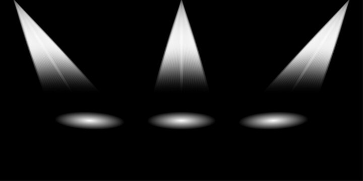 Three bright white spotlights shining down on a dark background creating a dramatic stage lighting effect
