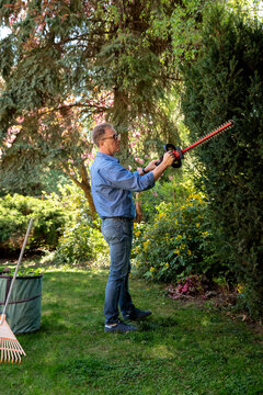 Full length of a senior mand gardening in a back yard
