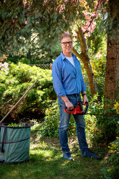 Full length of a senior mand gardening in a back yard