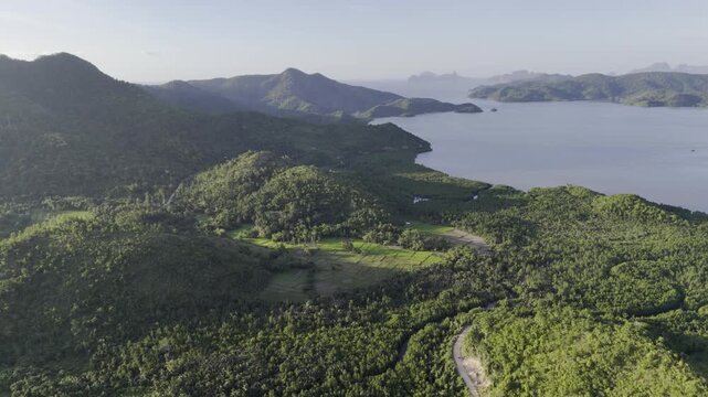 Aerial drone view of Coastal farmland beside mangroves and a quiet bay in Northern Palawan, Philippines