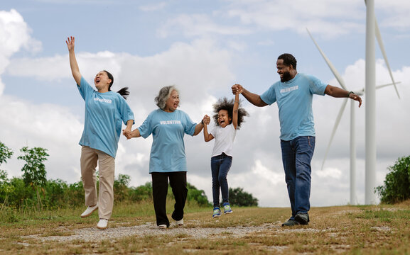 Family jumps joyfully on grassy hillside