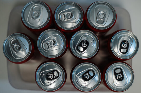 Ten soda cans sit in a tray, ready for use