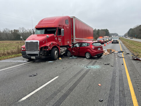 Red semi-truck crashed on road with debris scattered around
