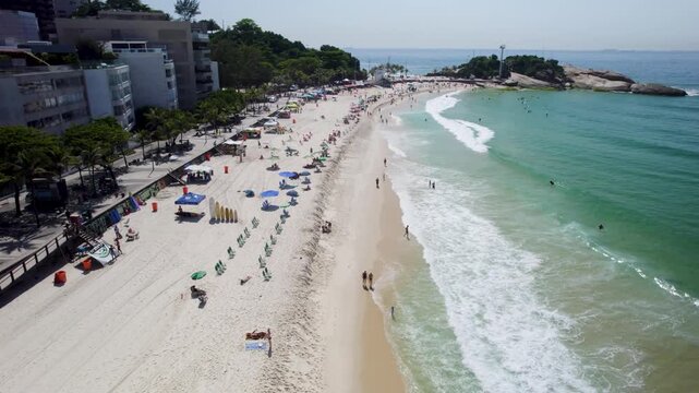 Drone going up framing the Ipanema beach shoreduring a beatiful summer day
