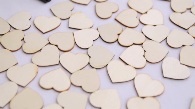 Handheld close up of wedding wishes jar with pens and wooden hearts