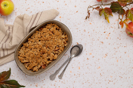 Freshly baked apple oat crumble on terrazzo table
