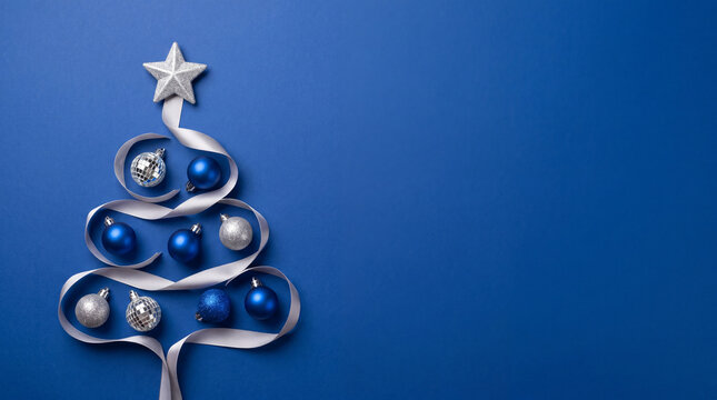 Stylized Christmas tree crafted from silver ribbon adorned with blue and silver baubles on a deep blue background with copy space.